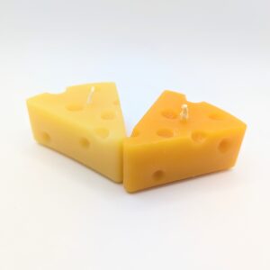 Two cheese-shaped candles; one light yellow and one dark yellow